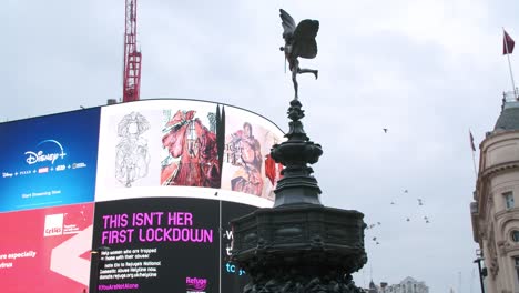Lockdown-in-London,-slow-motion-birds-flying-in-front-of-Piccadilly-Circus's-LED-'Thank-you-NHS'-signs-during-the-COVID-19-pandemic-2020