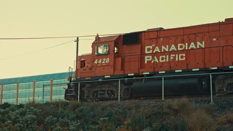 Locomotora-Del-Motor-Diesel-Del-Ferrocarril-Del-Pacífico-Canadiense-Tren-De-Carga-En-Ralentí-En-El-Puente-Del-Patio-Del-Ferrocarril-De-La-Ciudad-Industrial-Con-Una-Fuerte-Contaminación-Del-Aire-Distante-Al-Atardecer-Anochecer-Cinematográfico-Toronto-Ontario-Prores-4k