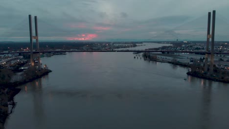 Drohnen-4K-Aufnahmen-Der-Alex-Fraser-Brücke,-Rückwärtsflug-Einer-Wunderschönen-Futuristischen-Hängebrücke,-Die-Die-Autobahn-Im-Sonnenuntergang-Freigibt