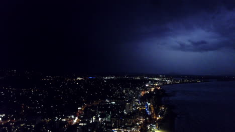 REALTIME-AERIAL-shot-of-an-electrical-storm-over-a-coastal-city-at-night