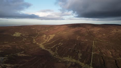 Aerial-View-Of-Turf-Hills-In-The-Wicklow-Mountains,-Ireland-On-An-Overcast-Day---drone-shot