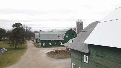 American-Flag-waving-with-green-barn-in-background-drone-video