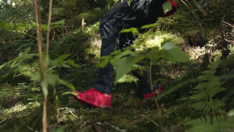 Man-In-Red-Shoes-Trail-Running-Down-A-Grassy-Hill-In-Alaska,-USA---Low-Level-Shot,-Slow-Motion