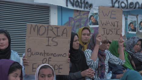 Mujeres-Afganas-Sosteniendo-Carteles-&quot;queremos-Justicia&quot;-En-La-Plaza-Safo-De-Mitilene-Tras-La-Muerte-De-Un-Hombre-Afgano-En-El-Campamento-De-Refugiados-De-Moria,-Tiro-Medio