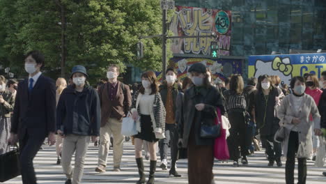Many-People-Crossing-At-Shibuya-Crossing-During-The-Worldwide-Pandemic-Coronavirus-In-Tokyo,-Japan---People-In-Facemask-Protection-Against-COVID-19