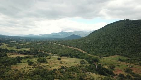 Aerial-View-of-the-Green-Plains-in-Mountains-and-Trafic-Road,-Tanzania,-Africa