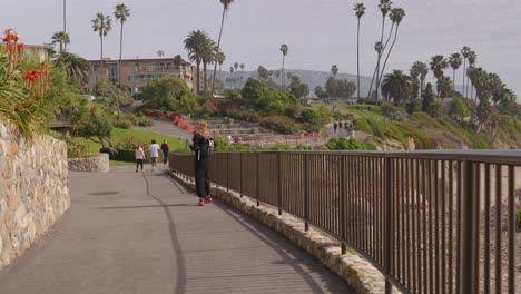 Chica-Pasando-El-Rato-En-Heisler-Park,-En-Laguna-Beach,-California,-Tiene-Su-Atención-Captada-Por-Algo-Sobre-Su-Cabeza,-Ralentizada-A-La-Mitad-De-Velocidad.