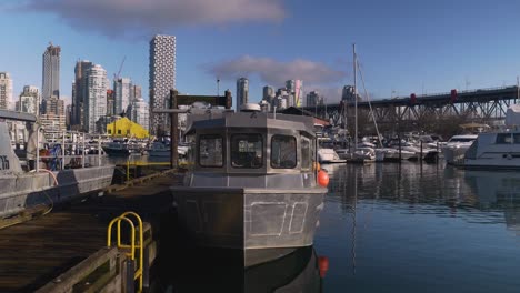 A-metal-fishing-boat-moored-at-Granville-Island-Fisherman's-wharf-loaded-with-fishing-equipment-and-buoys