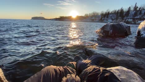 first-person-video-guy-starring-to-the-sunset-in-lake-superior-shore-line-in-minnesota-during-winter