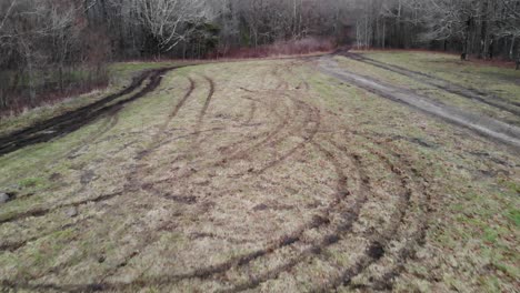 tire-tracks-in-grass-field-destroyed-aerial-drone-tracking