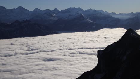 Lapso-De-Tiempo-De-Niebla-En-Rápido-Movimiento-Con-Montañas-Suizas-Nevadas-Y-Clima-Soleado-Arriba