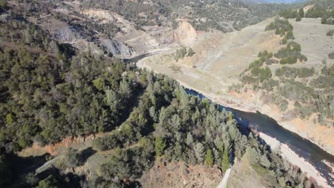 Real-time-drone-footage-from-the-countryside-surrounding-Auburn,-California,-USA---beautiful-forested-canyon-with-river-at-the-base-on-a-sunny-day,-in-an-area-famed-for-it's-gold-rush-history