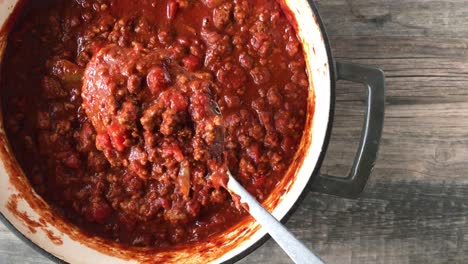 top-view-of-big-pot-of-bean-less-chili-with-lifted-spoonful