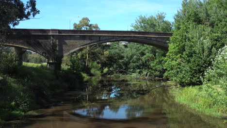 AERIAL-Towards-Historic-Cement-Arched-Bridge-Over-Moorabool-River-Geelong