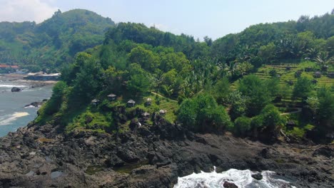 Tiny-huts-on-cliff-by-Menganti-beach,-Central-Java