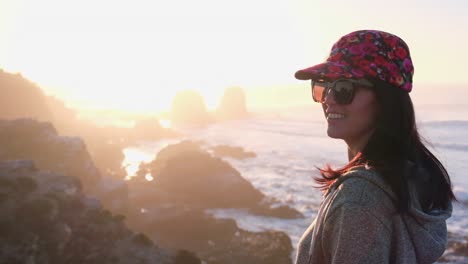 woman-from-back-watching-the-sunset-with-the-sun-in-the-sea-on-surf-beach-in-punta-de-lobos