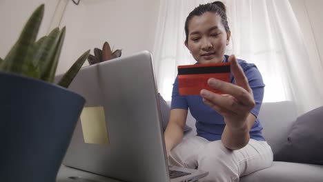 Asiatische-Geschäftsfrauen-Nutzen-Karten,-Um-Online-Einkäufe-Auf-Einem-Laptop-Zu-Bezahlen