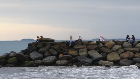 visitors-relax-waiting-for-the-sunset-on-the-beach-in-the-city-of-Padang,-West-Sumatra,-May-21,-2022