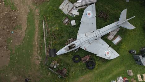 Aerial-view-circling-above-military-Hawker-hunter-WT804-jet-on-farmland-scrap-yard