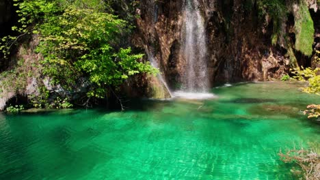Wasserfall-Fließt-über-Felsen-In-Einen-Fluss-Mit-Türkisfarbenem-Wasser---Luftaufnahme