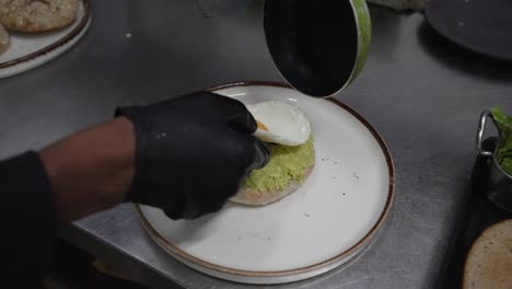 Sándwich-De-Huevo-Y-Aguacate-Con-Pan-Integral-Servido-En-Un-Plato,-Manos-Del-Chef