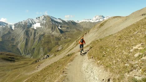 Mountain-biking-on-a-beautiful-single-trail-with-stunning-view-across-big-snow-coverd-mountains