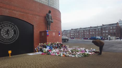 A-well-wisher-reads-the-cards-and-flowers-left-by-people-for-the-50th-Anniversary-of-the-Ibrox-Disaster
