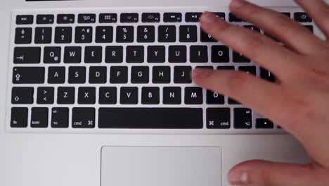 Full-Top-View-Of-A-Laptop-Keyboard-With-Hand-Typing-Apple-Word-And-Press-Enter-Button,-overhead-shot