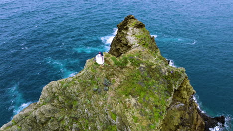 Aerial-orbit-around-Porto-Moniz-lighthouse-atop-craggy-Ilheu-Mole-island