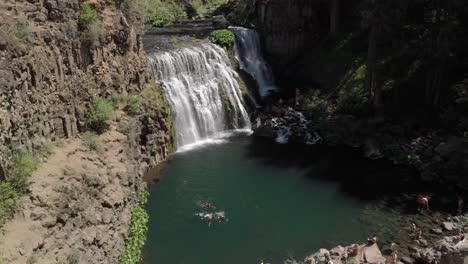 Proximity-aerial-reveals-swimmers-in-green-pool-below-McCloud-Falls