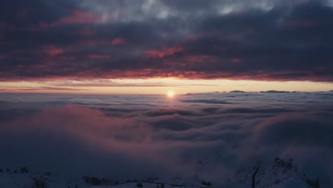Epic-aerial-drone-shot-showing-sunset-over-cloudscape-and-mountains