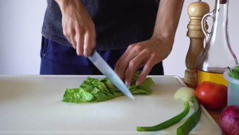Hands-Cutting-Fresh-Lettuce-With-A-Metal-Knife-On-Chopping-Board---close-up