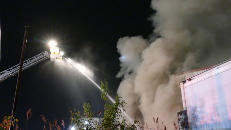 Firefighters-extinguish-a-fire-from-a-crane-with-water-with-thick-smoke