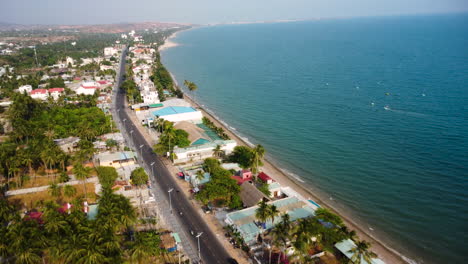 Coastal-main-road-of-Mui-Ne-with-luxury-hotels-and-buildings,-aerial-view