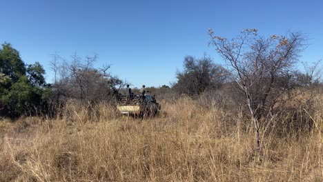 animal-reserve-rangers-patrolling-a-savannah-area-in-an-offroad-truck,-to-prevent-poaching