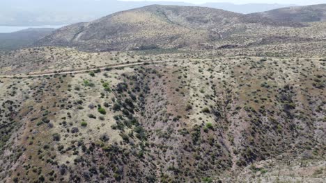 Video-De-Drones-De-Las-Montañas-Y-El-Desierto-De-Arizona-Con-Un-Automóvil-Conduciendo-A-Lo-Lejos