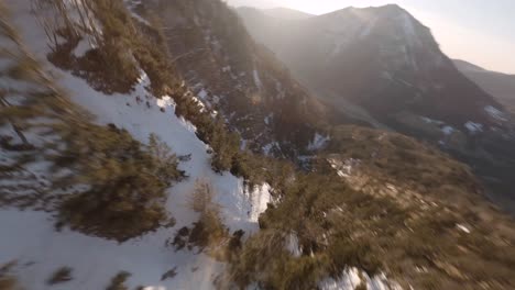 fpv-drone-diving-down-an-austrian-mountain-at-spring-in-the-evening-sun
