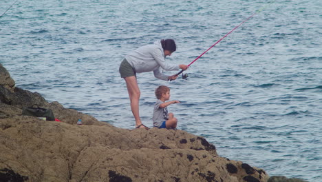 A-Mother-and-Child-Bond-While-Fishing-on-the-Rocks-in-Cornwall,-England