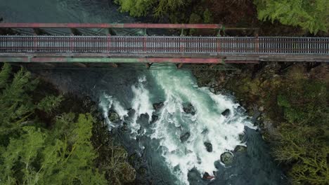 Lewis-river-churns-through-rapids-and-flows-under-steel-railroad-bridge