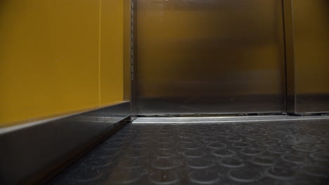 Elevator's-door-opening,-view-from-inside.-Yellow-escalator