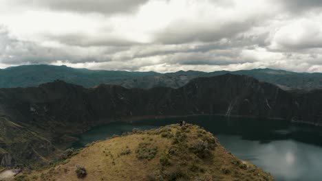 People-on-mountaintop-admiring-beautiful-crater-lake-view-and-volcano-scenery-in-Ecuador