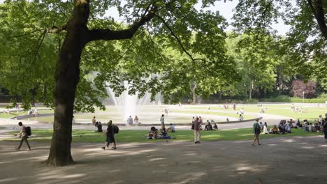 Menschen-Hängen-Am-Square-De-La-Bouteille-Mit-Springbrunnen-Im-Jubiläumspark,-Brüssel,-Belgien