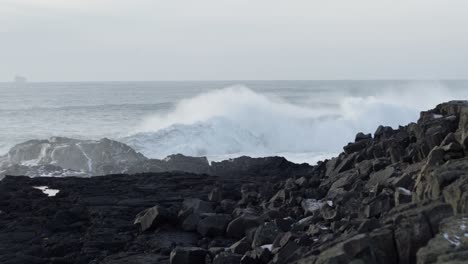 Large-stormy-swell-near-rugged-shore-of-Iceland,-wave-crashing,-slow-motion