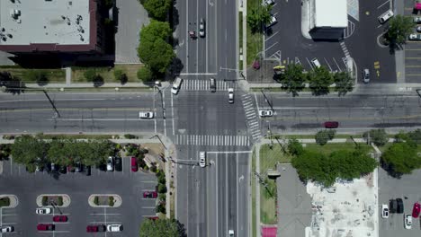 Vehicles-Crossing-and-Driving-through-Intersection-in-Urban-City-Streets,-Aerial
