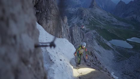 Female-mountaineer-with-headlight-and-climbing-gear-on-a-"via-ferrata"-in-the-Dolomites
