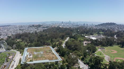 Aerial-descending-and-panning-shot-of-the-California-Academy-of-Sciences-museum-in-Golden-Gate-Park,-San-Francisco