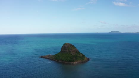 Aerial-reverse-pullback-shot-of-Mokoli'i-island,-also-known-as-Chinaman's-Hat,-on-the-island-of-O'ahu,-Hawaii