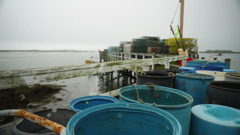 Equipo-De-Pesca-Y-Trampas-Para-Langostas-En-El-Muelle-Con-Vistas-Al-Puerto-Deportivo-Del-Océano-En-Maine-4k-60p