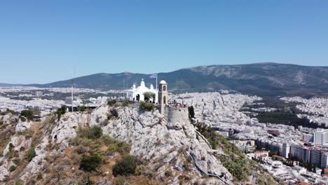 Orbiting-drone-video-of-Mount-Lycabettus,-in-Athens,-Greece