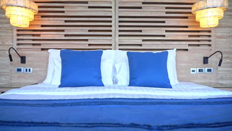 Panorámica-Derecha-A-Fieltro-A-Través-De-Una-Cama-De-Suite-De-Hotel-Hecha-Con-Cojines-Y-Cobertores-De-Acento-Azul.